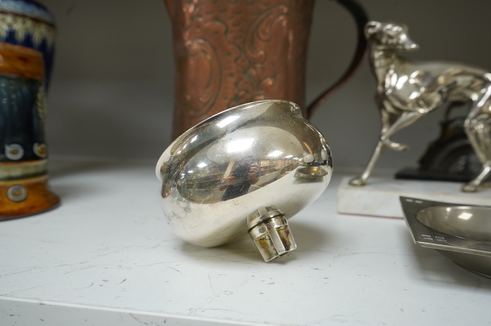 A pair of French Art Deco stag bookends, a chrome Greyhound mounted on a marble base, a large Arts and Crafts copper jug and two other items, jug 27cm high